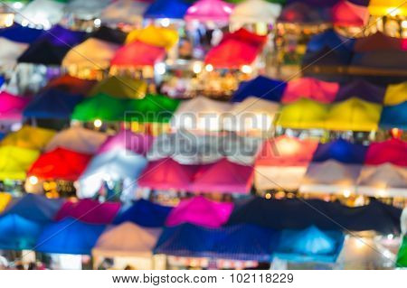 Close up multiple colours umbrella of weekend market, blurred bokeh lights background