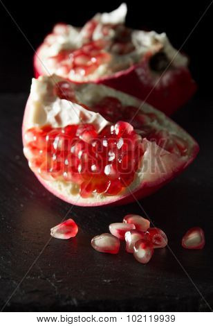 Small Heap Of Pomegranate Seeds On Black Slate Surface