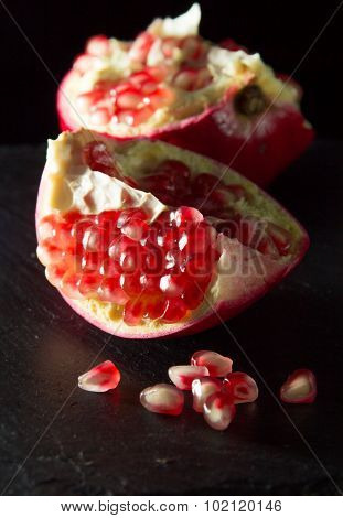 Small Heap Of Pomegranate Seeds On Black Slate Surface