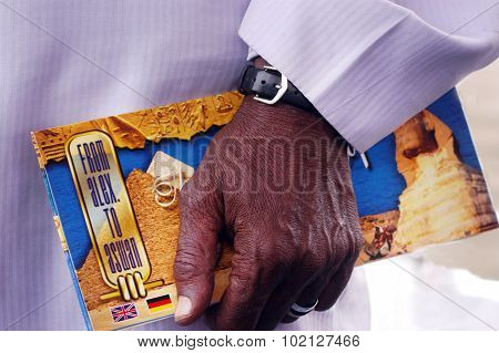Nubian Egyptian man holds Egyptian Tour Guide Map in Aswan Egypt.