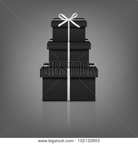 Stack of three realistic black gift boxes with white ribbon and bow