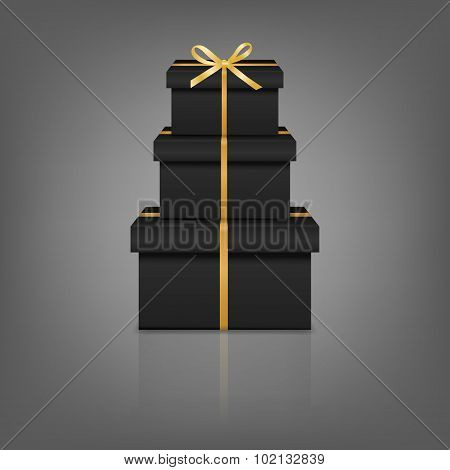 Stack of three realistic black gift boxes with golden ribbon and bow