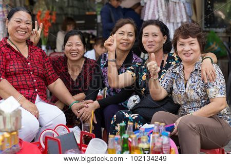 HO CHI MINH VILLE, VIETNAM, FEBRUARY 26, 2015 : A group of friendly vegetable sellers is posing in the street of Chinatown of Ho Chi Minh Ville, (Saigon), Vietnam.