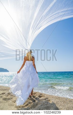 Young bride in white wedding dress  on the beach in Greece