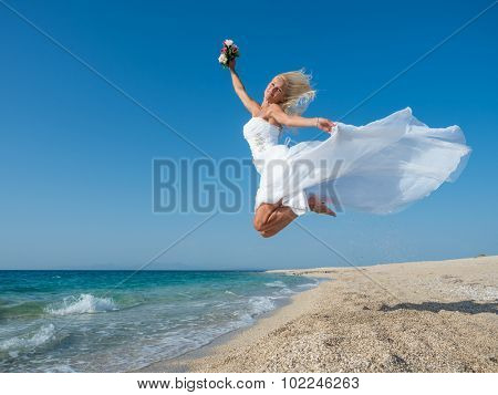 Young bride in white wedding dress  on the beach in Greece