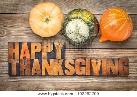 Happy Thanksgiving greeting card - text in vintage letterpress wood type blocks against rustic weathered wood with winter squash