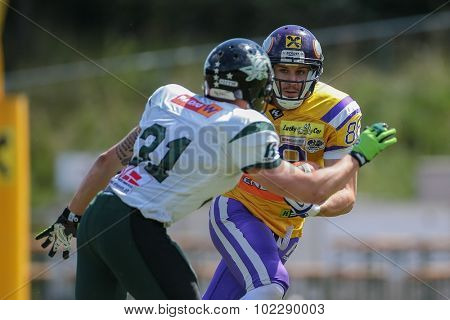 VIENNA, AUSTRIA - JUNE 22, 2014: WR Stefan Postel (#88 Vikings) is tackled by CB Christian Kober (#31 Dragons).