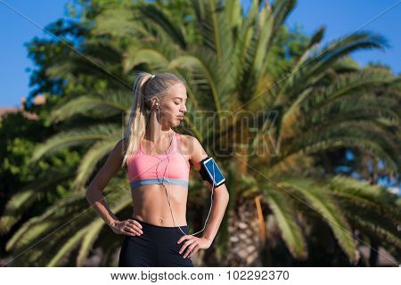 Female jogger with closed eyes enjoying sunny day and rest after workout