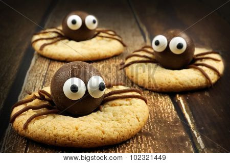 Chocolate Halloween spider cookies on rustic wood