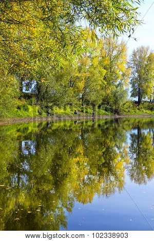 Autumn landscape on the river with fishermen