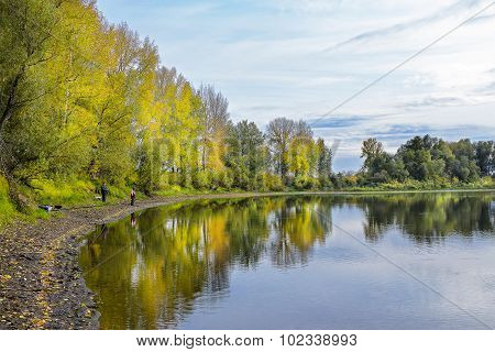 Autumn landscape on the river with fishermen