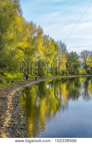 Autumn landscape on the river with fishermen