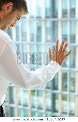 Young caucassian businessman standing against office window
