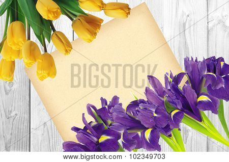 Blueflag Or Iris Flower And Yellow Tulips With Greeting Card On White Wooden Background
