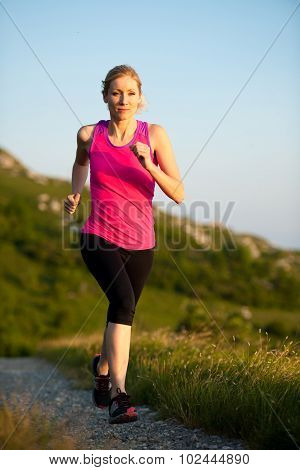 Beautiful Young Woman Runns Cross Country On A Mountian Path At Sunrise