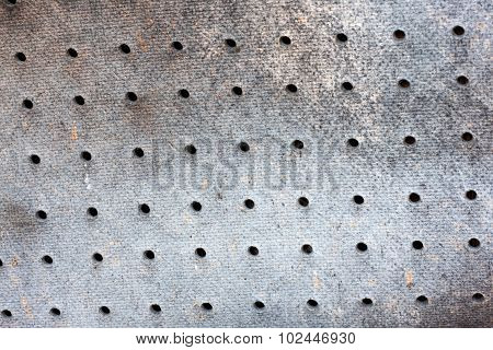 Old grey dirty fiberboard with holes in it