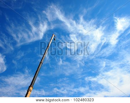 The Boom Of The Crane On A Diagonal Against A Blue Sky