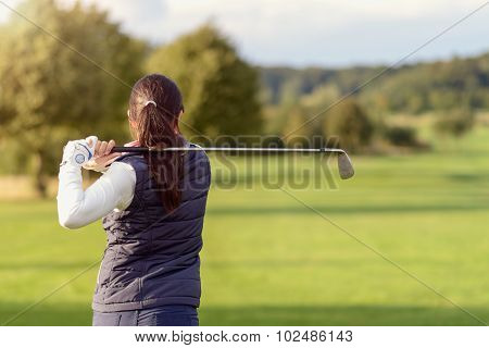 Female Golfer Striking The Golf Ball