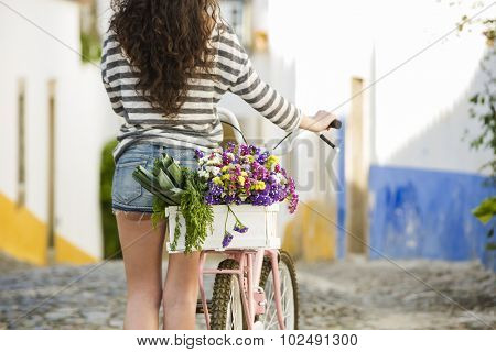 Beautiful female tourist living like a local, with her bicycle after buying some fresh vegetables