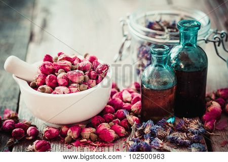 Mortar With Rose Buds, Bottles Of Tincture And Dried Forget Me Not Flowers. Herbal Tea Assortment.