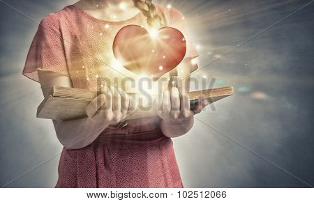 Young emotional woman in red dress with book in hand