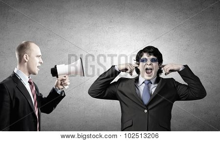 Young furious man screaming agressively in megaphone