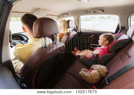 family, transport, safety, road trip and people concept - happy parents with little child driving in car