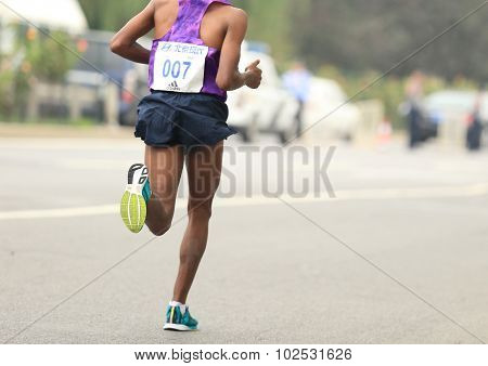 Marathon runner running on city road