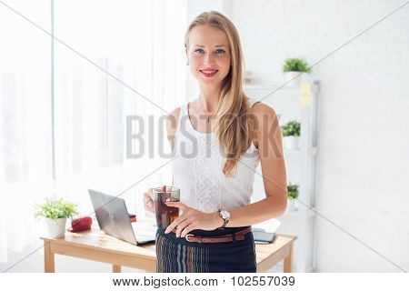 Portait of beautiful successful business woman holding cup coffee looking at camera