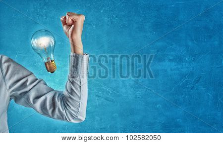 Hand of business person showing power concept  and glowing light bulb