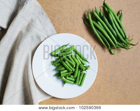 Sliced Green Beans On A White Plate And A Bunch Of Green Beans On The Table With A Napkin