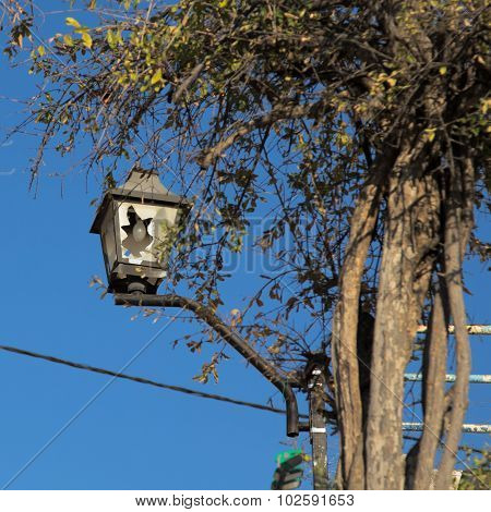 Broken City Light On The Blue Sky Background.