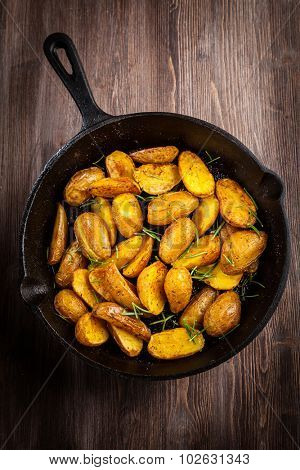 Rustic baked potatoes withherbs in a pan