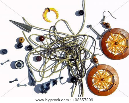 Background with Piercing earrings, orange earrings, beads, ropes for bracelets