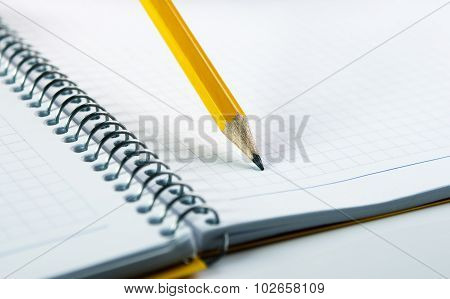 Yellow pancil on blank notebook with spiral