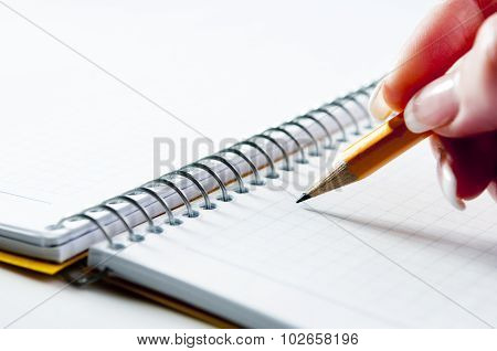 Yellow pancil on blank notebook with spiral