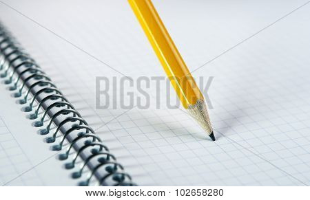 Yellow pancil on blank notebook with spiral