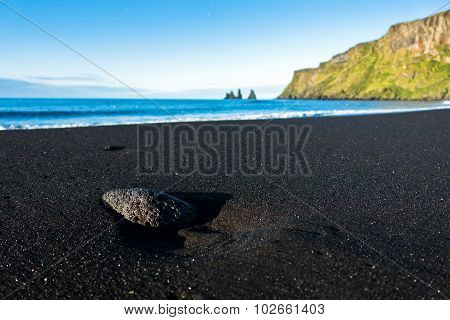 Texture of beautiful black volcanic sand beach in Vik at sunrise