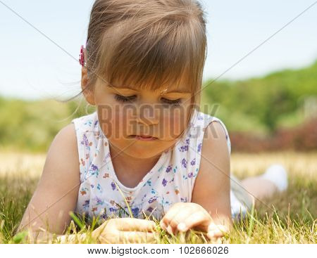 Little Girl Lying On Grass In The Park