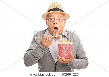 Baffled senior gentleman eating Chinese food with sticks and looking at the camera isolated on white background