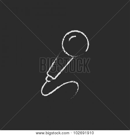 Microphone hand drawn in chalk on a blackboard vector white icon isolated on a black background.