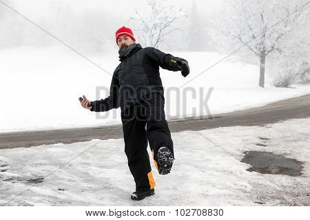 Man With Mobile Phone Is Slipping On A Freezy Street