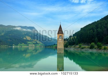Beautiful view of the lake Resia. Famous tower in the water. Alps, Italy, Europe.