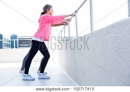 Women leaning on railing while exercising outdoors