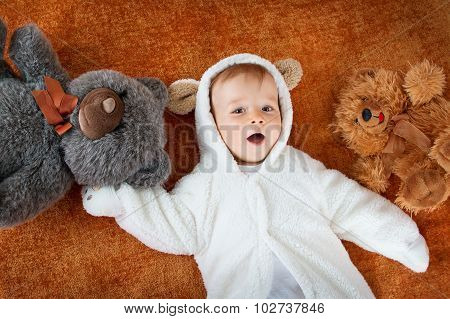 Little baby in bear costume with plush toys
