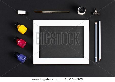 Template With White Photo Frame On Pink Paper With Brushes And Gouache And Pencils. Painter Workplac