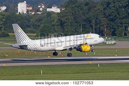ZURICH - JULY 18: Airbus A-320 Vueling landing in Zurich after short haul flight on July 18, 2015 in Zurich, Switzerland. Zurich airport is home for Swiss Air and one of biggest european hubs.
