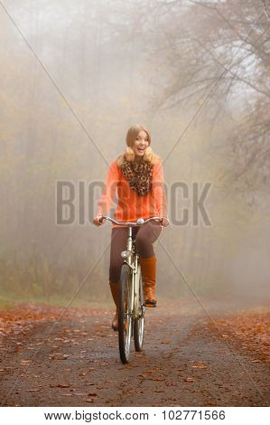 Girl Relaxing In Autumnal Park With Bicycle