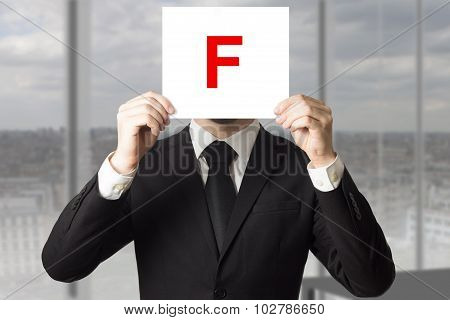 Businessman In Suit Holding Up Sign With Letter F