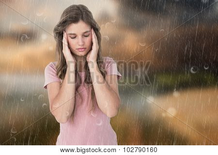Pretty woman with headache hands on temples against country scene
